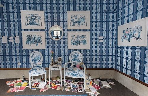 Photo of Art Installation titled Beyond a Room of One's Own from the SHE exhibition at ArtsWestchester in 2016. Colors are blue and white with Victorian era chairs and books scattered on the floor, framed pictures of famous women of world history.