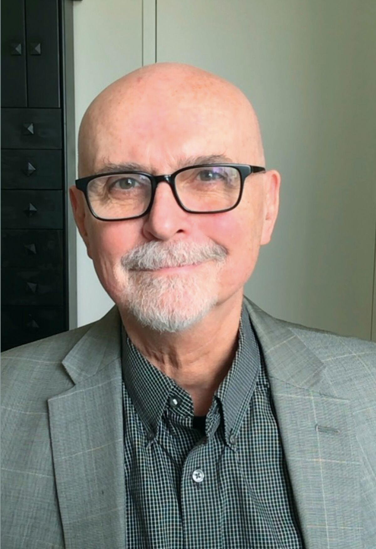 A head of the author , Richard Lacayo. He wears glasses, has a gray beard, is wearing a sport jacket (gray) with a maroon shirt).
