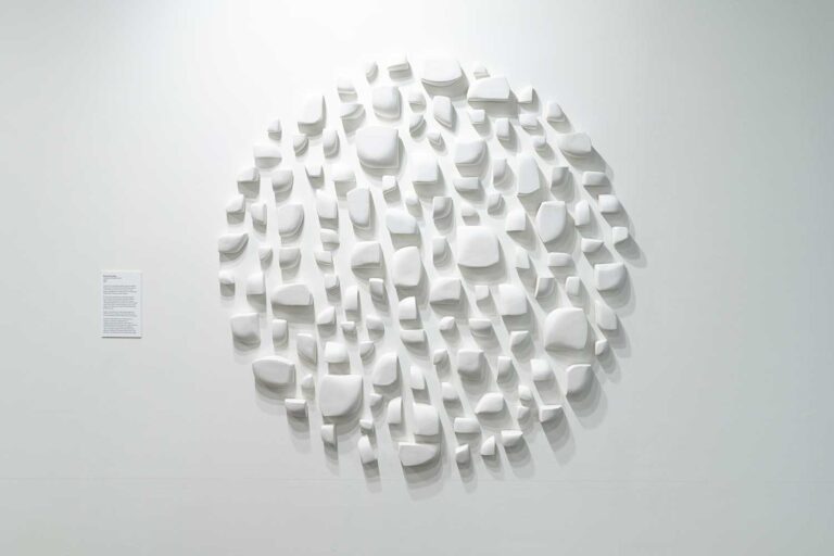 White stones arranged in a sphere casting shadow patterns
